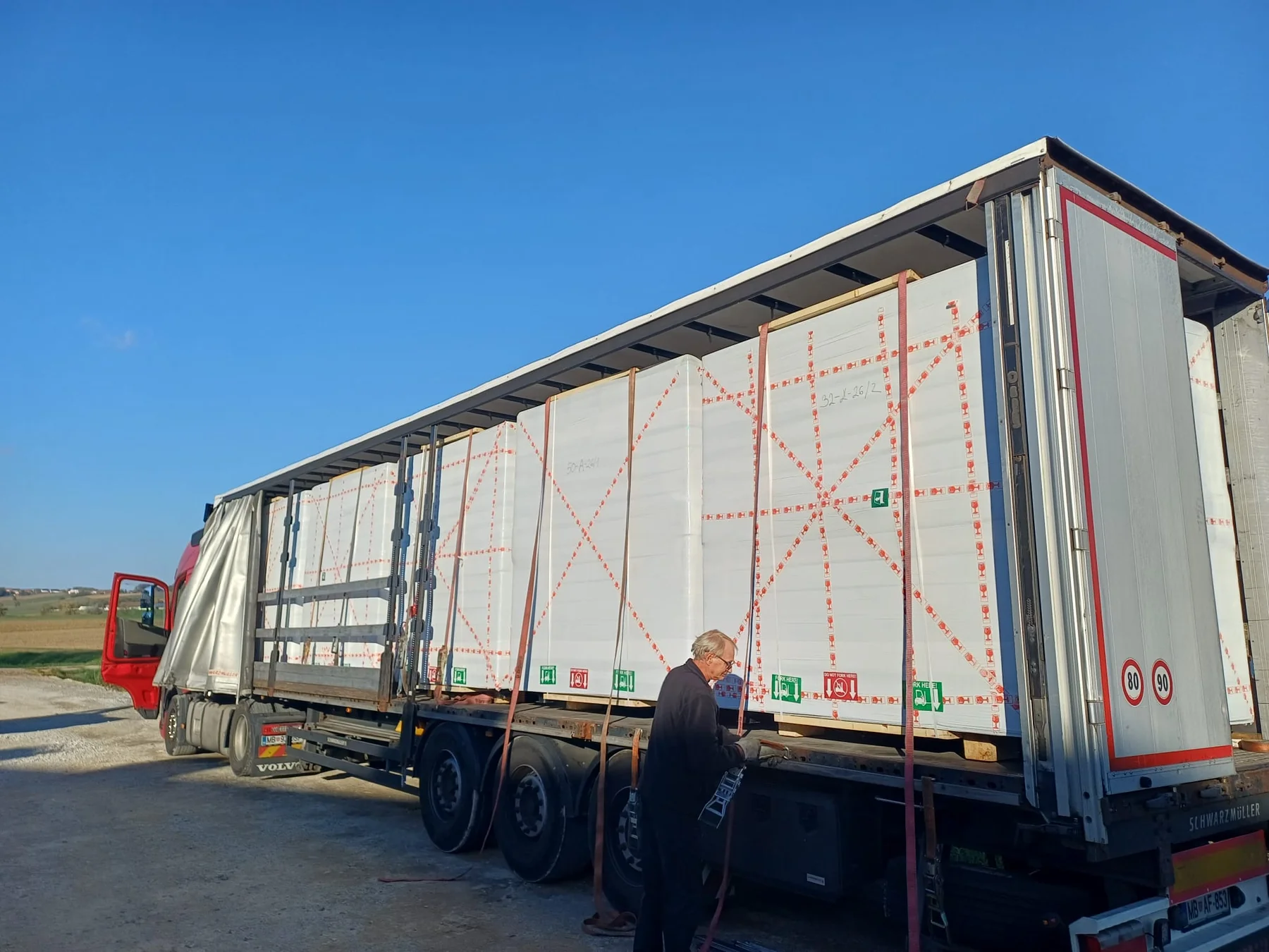 Wrapped prefabricated units secured on a truck for road transport